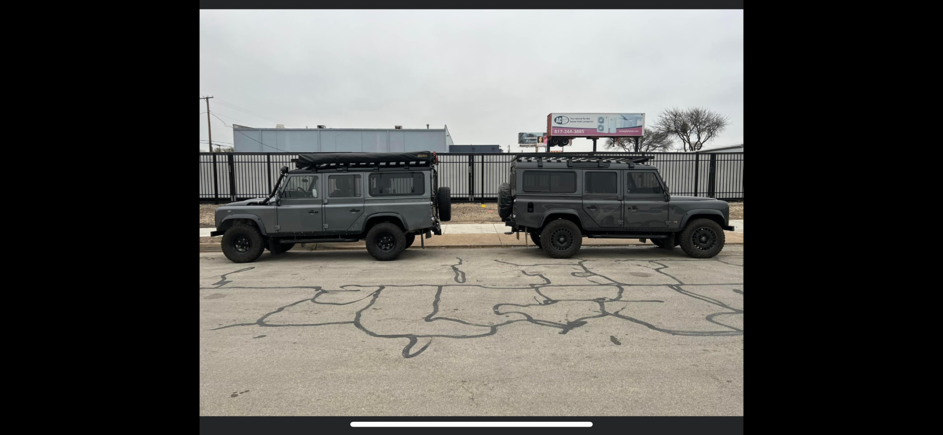 Two slate grey Defender 110 overland builds parked side by side