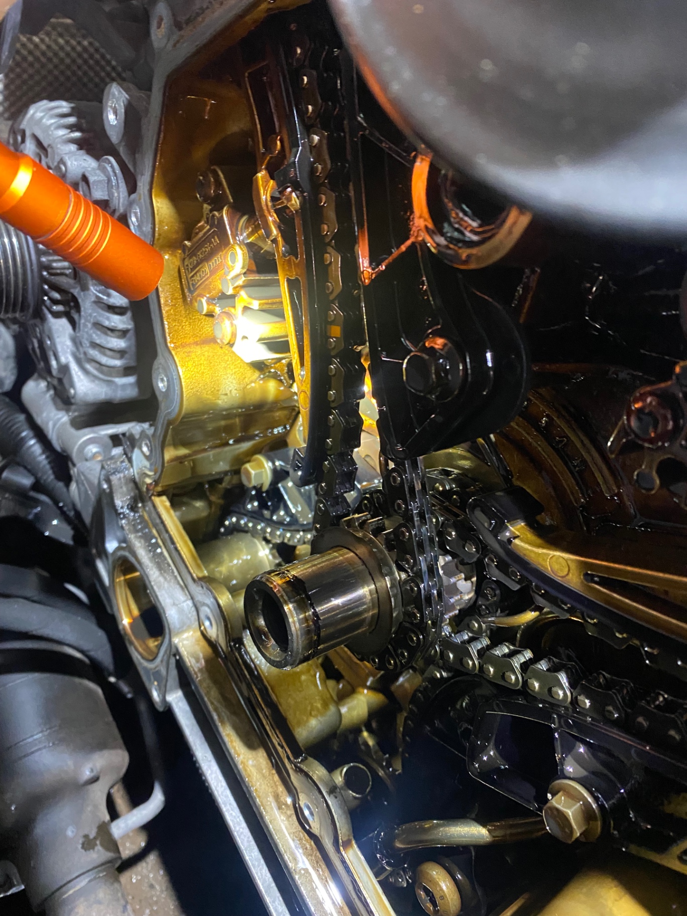 Timing cover open on a Rover engine with chains and tensioners visible