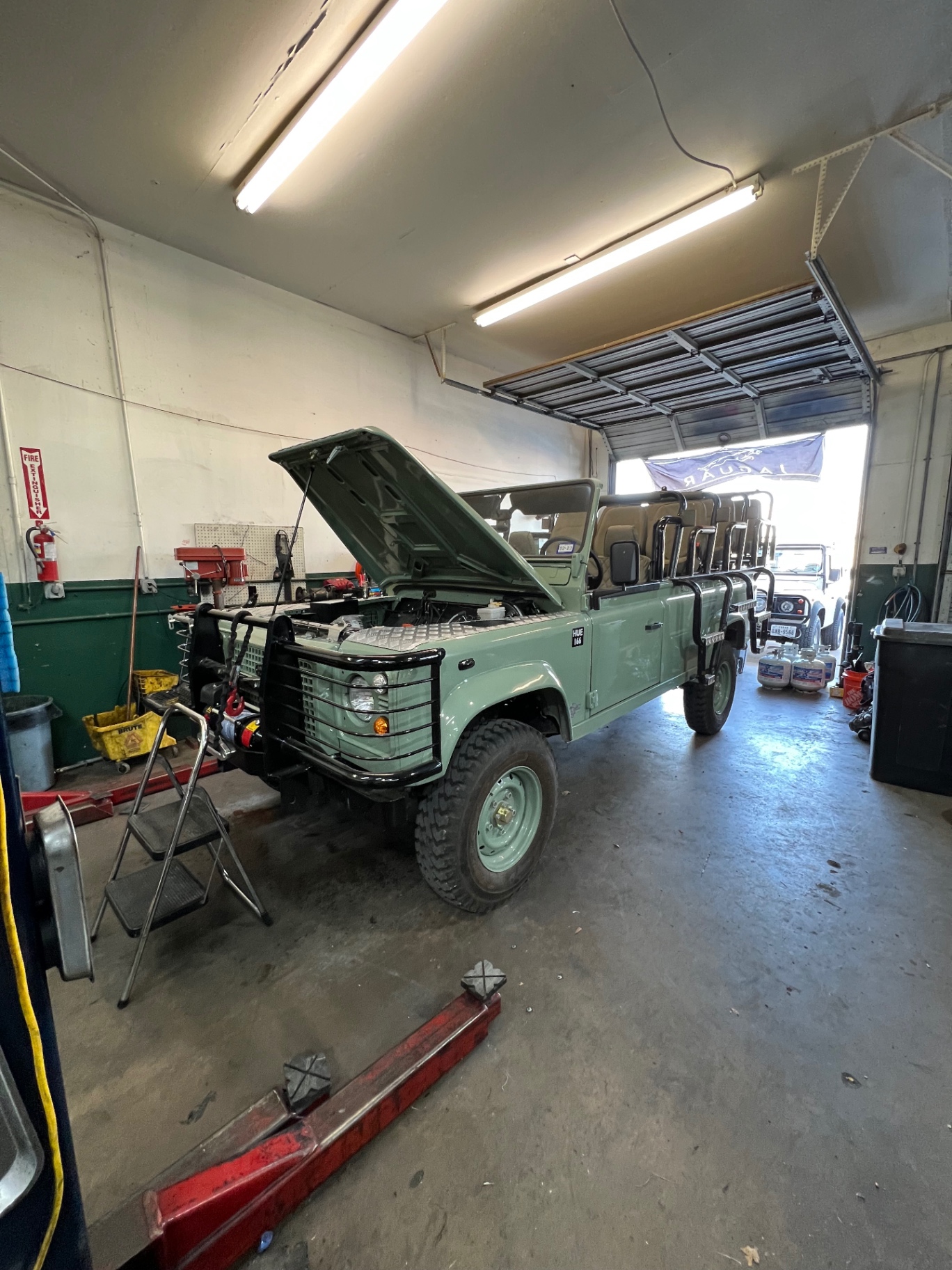 Heritage mint Defender 110 safari build with bench seats inside the shop