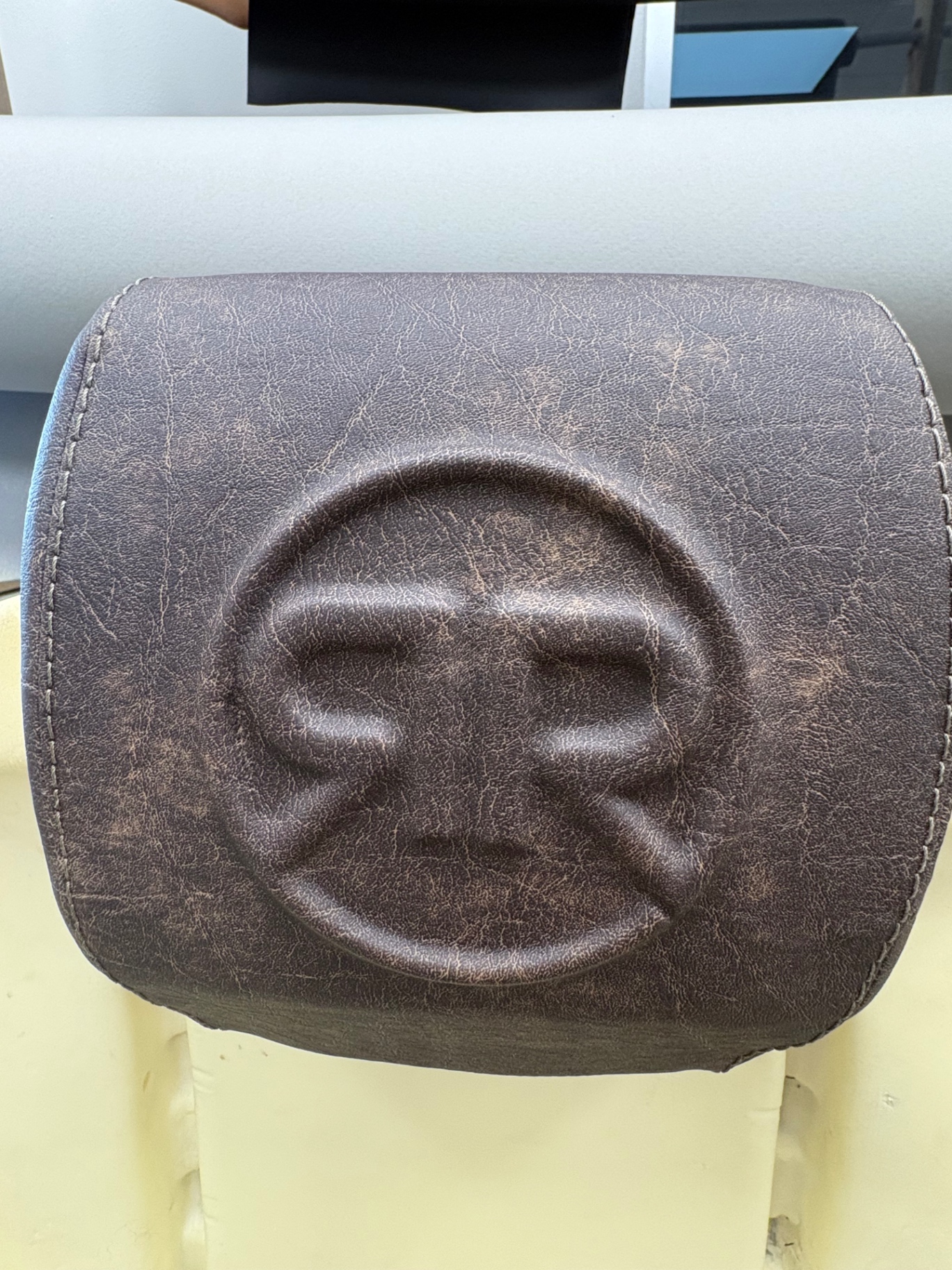 Distressed brown leather headrest embossed with Rovers R Us logo
