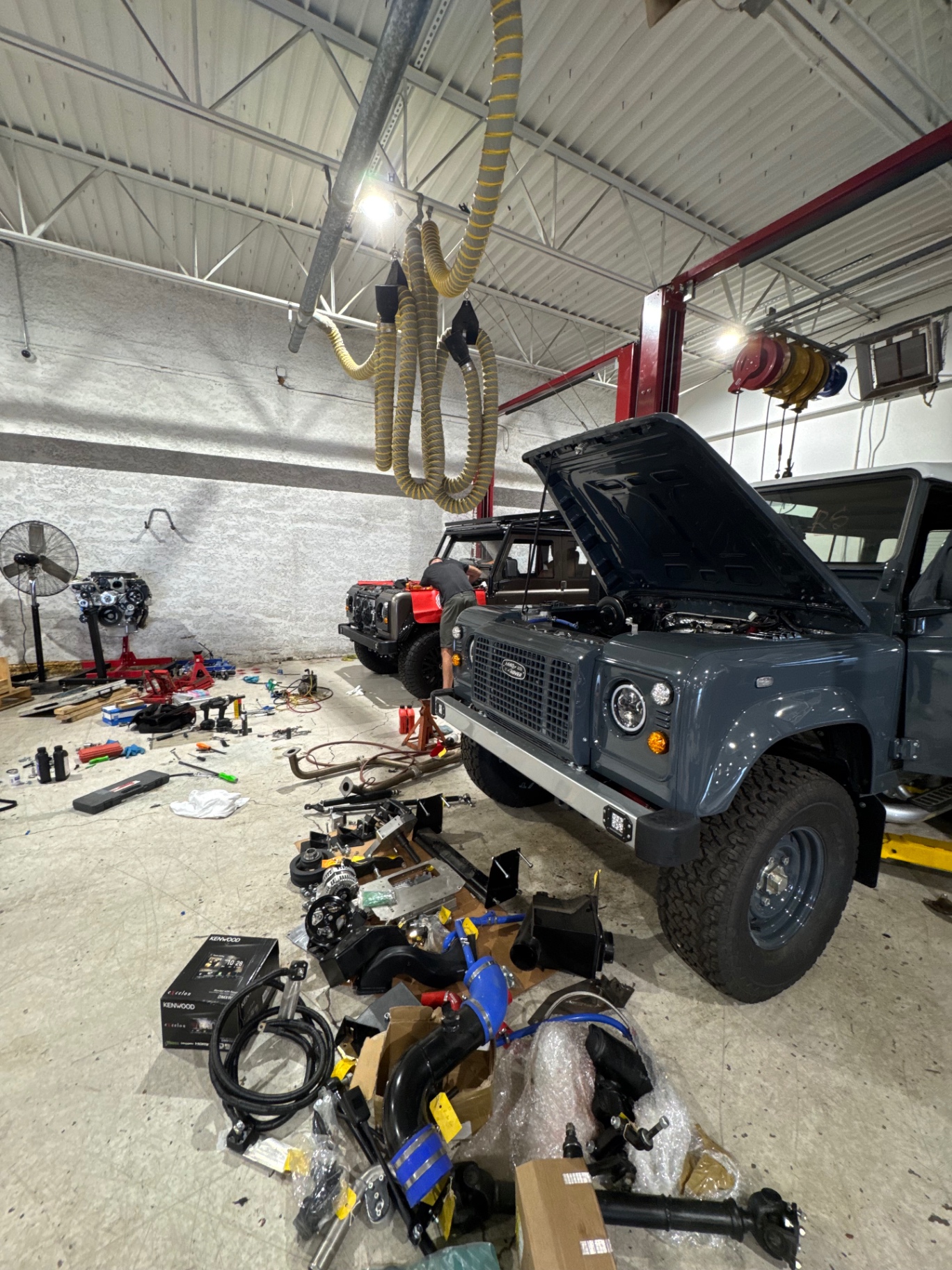 Slate Defender 110 in the workshop mid-build with GM conversion parts staged