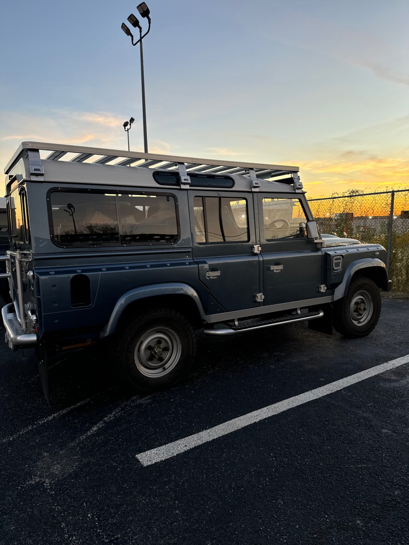Slate blue Defender 110 at sunset