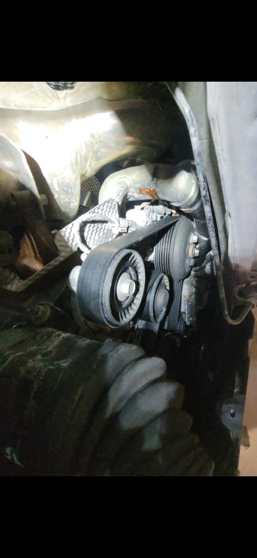 Serpentine belt and tensioner assembly during a belt service