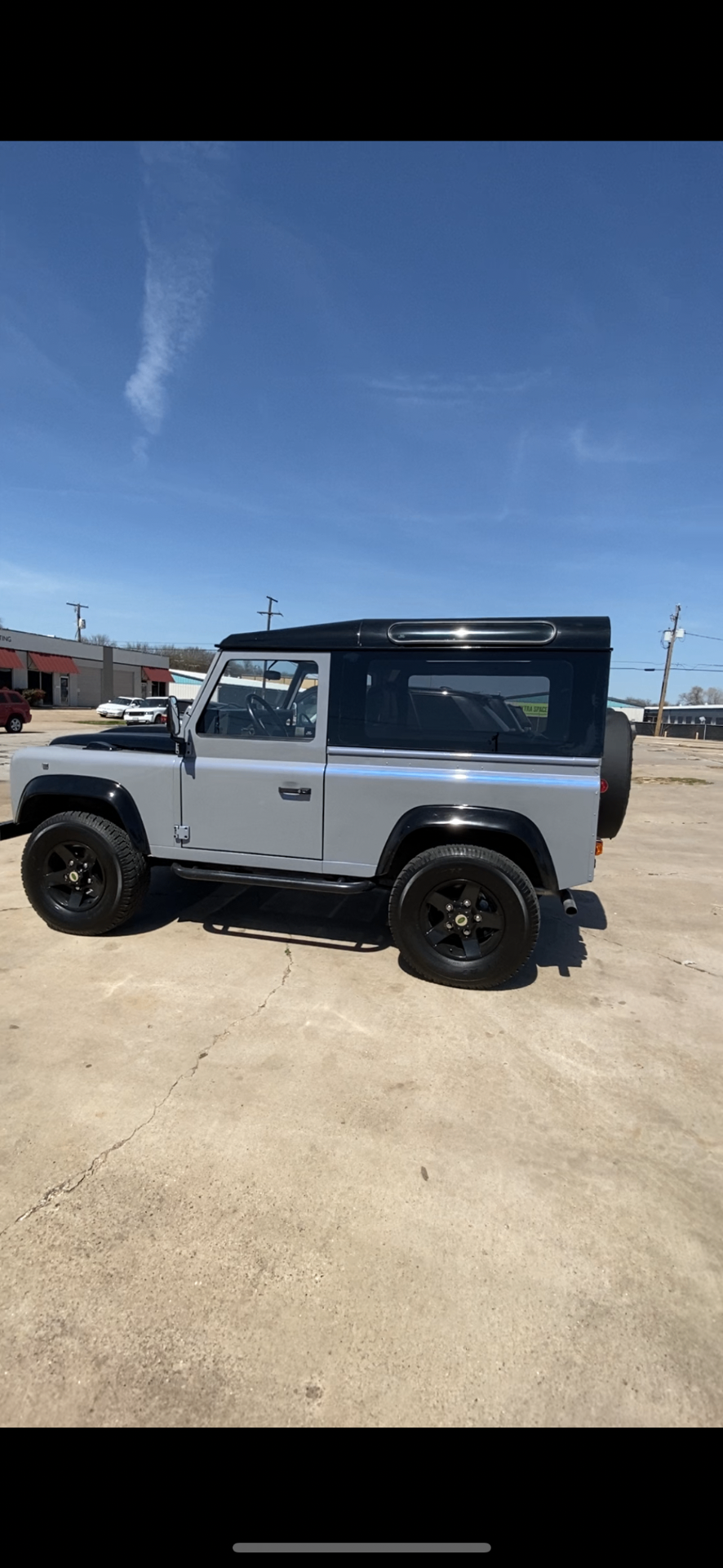 Silver Land Rover Defender 90 hardtop with black roof and black modular wheels