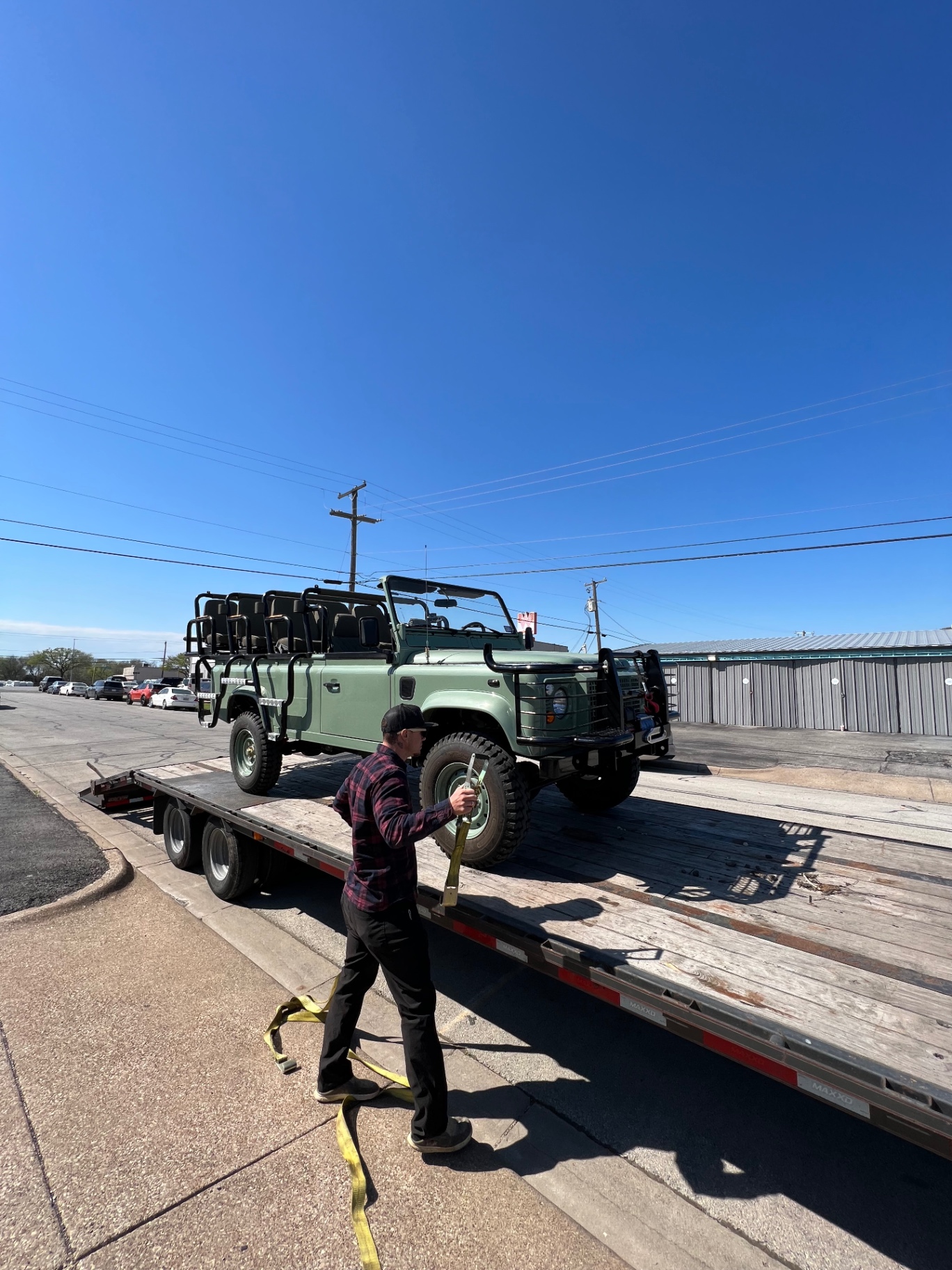 Heritage mint Defender 110 safari loaded on a flatbed trailer for delivery