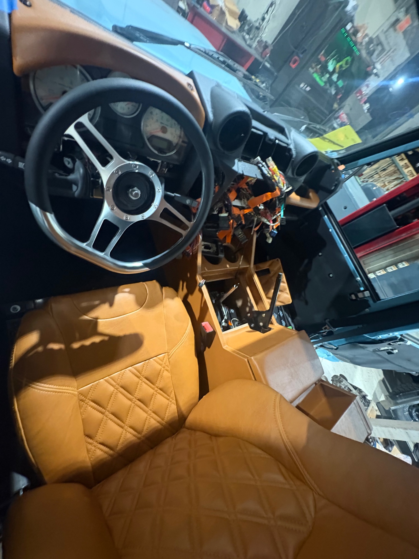Tan quilted seats and console next to Defender dashboard build